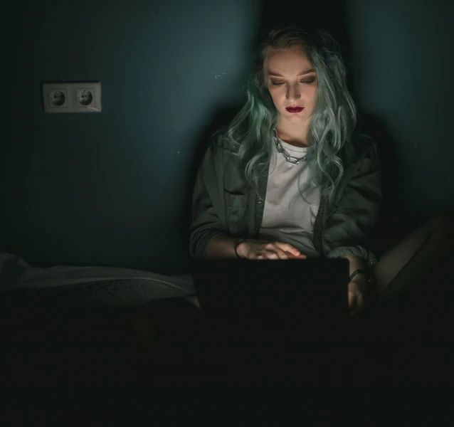 Jeune femme utilisant un ordinateur pour s’informer sur l’addiction au sexe et les comportements sexuels compulsifs