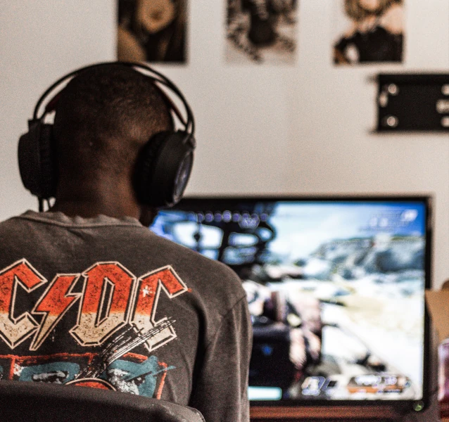 Adolescent jouant aux jeux vidéo seul dans sa chambre illustrant l’isolement social lié à une pratique excessive