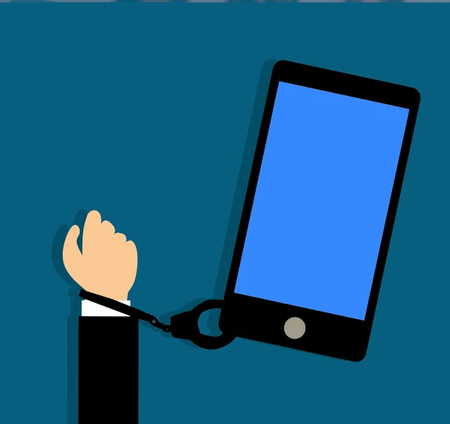 Main menottée tenant un téléphone, symbolisant la perte de contrôle liée à l’usage de la pornographie sur smartphone.